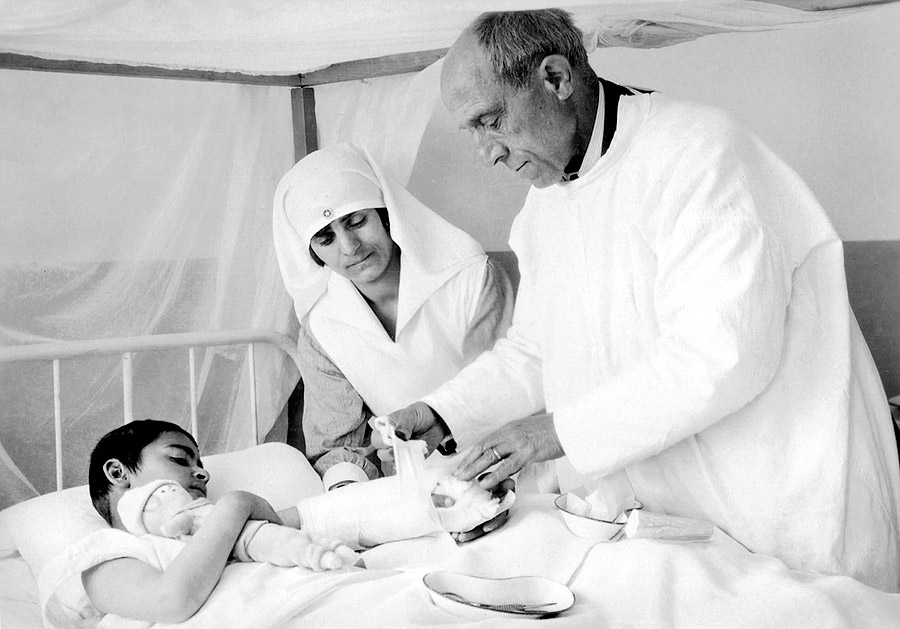 Griekse arts en verpleegkundige spalken de gebroken arm van een Armeense jongen
